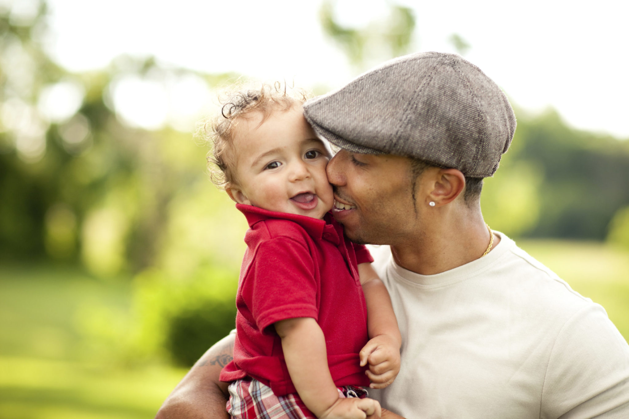 Father kissing his toddler son on the cheek