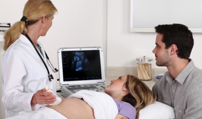 Father, mother, and doctor at ultrasound appointment