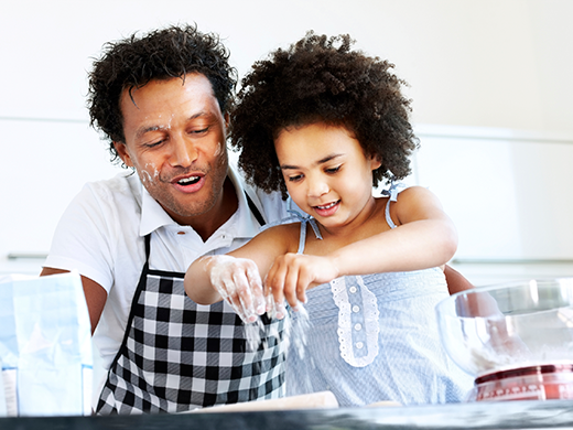 Father and young daughter baking together