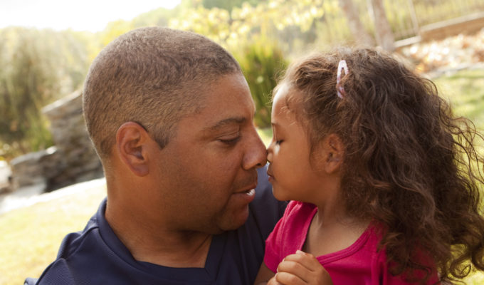 Father and young daughter eskimo kiss