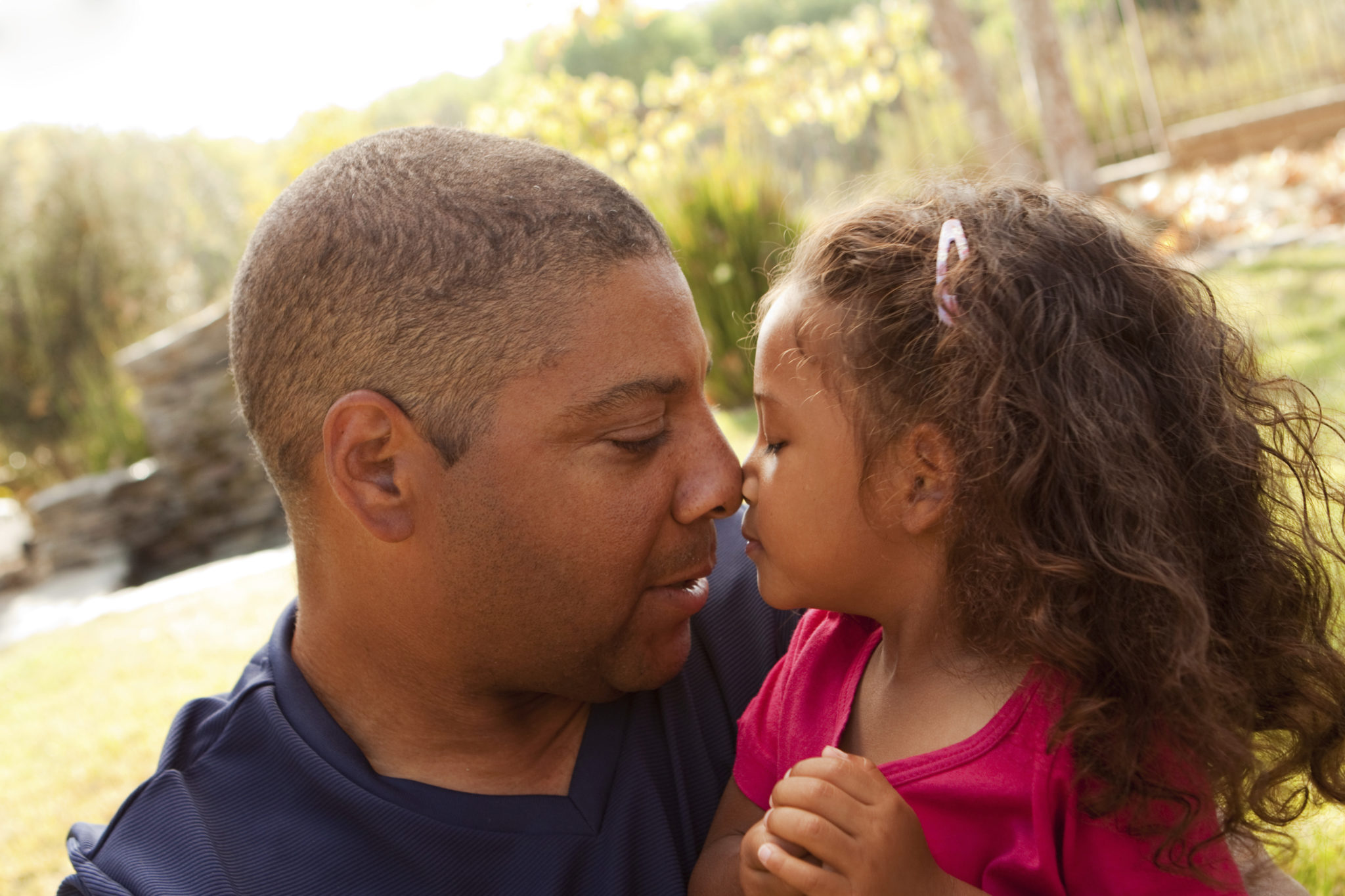 Father and young daughter eskimo kiss